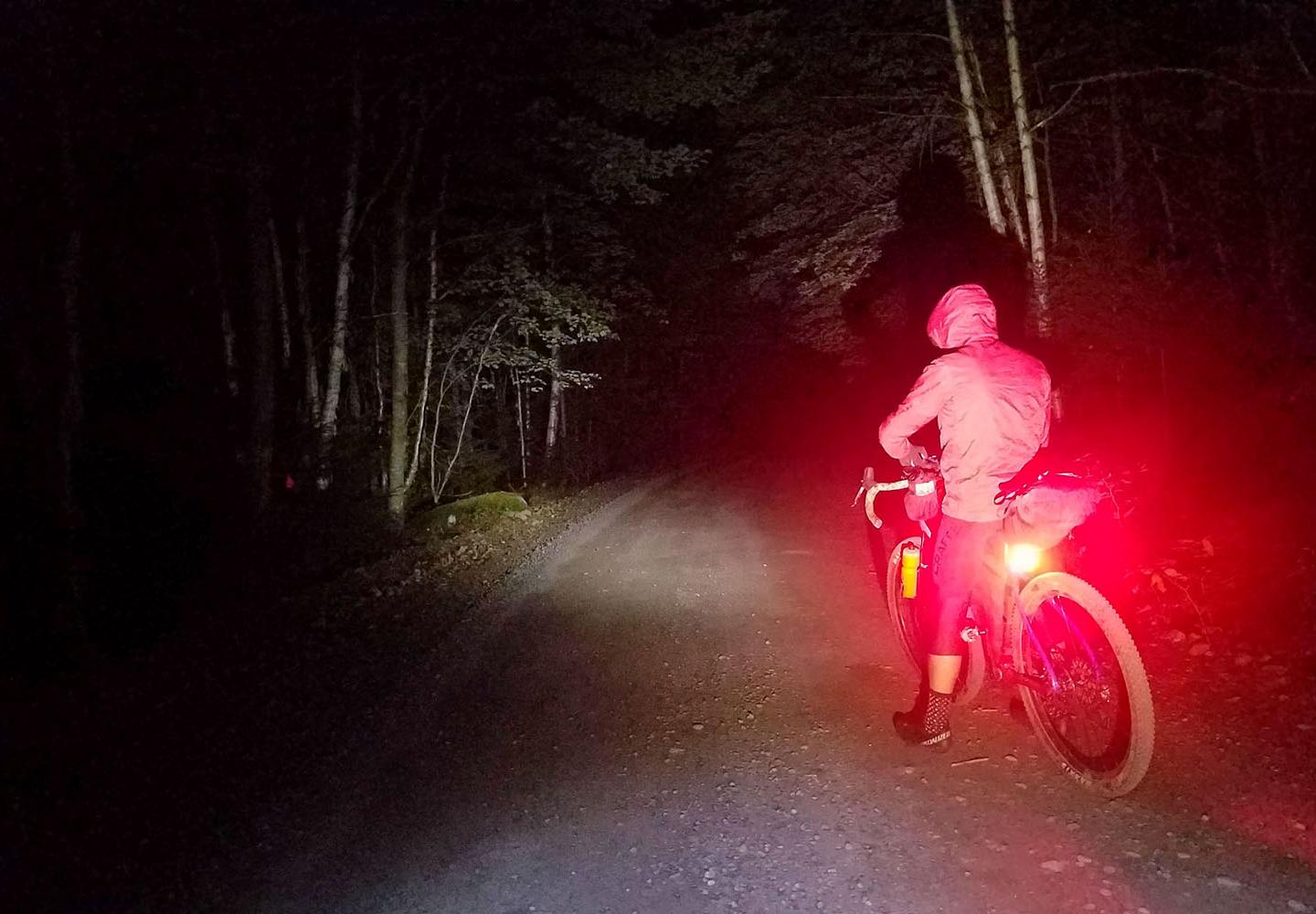 Jeremiah Macrae-Hawkins stops for a snack in the early morning darkness of day 2, in the forest northwest of Inlet.