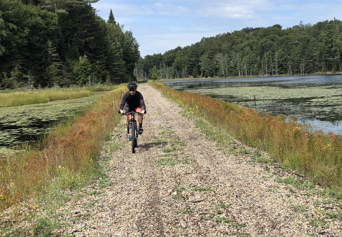 A cyclists pedals along the Adirondack Rail Trail near Saranac Lake, NY.