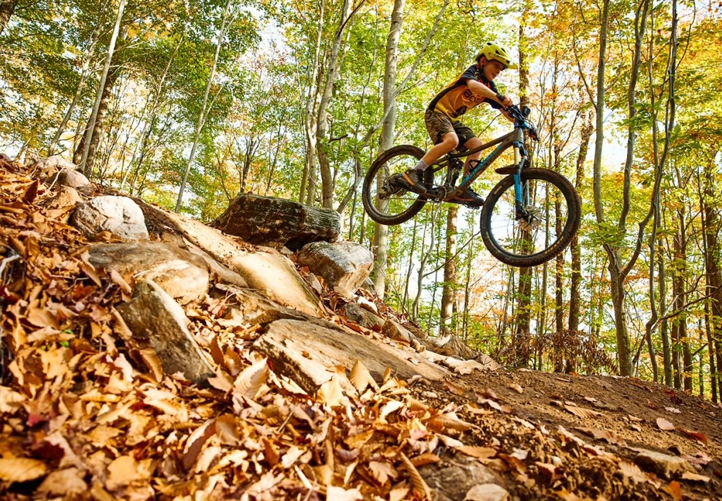 A rider clears a jump at the Wheelerville trail network in Caroga, part of the Adirondack Foothills Trails Alliance network.