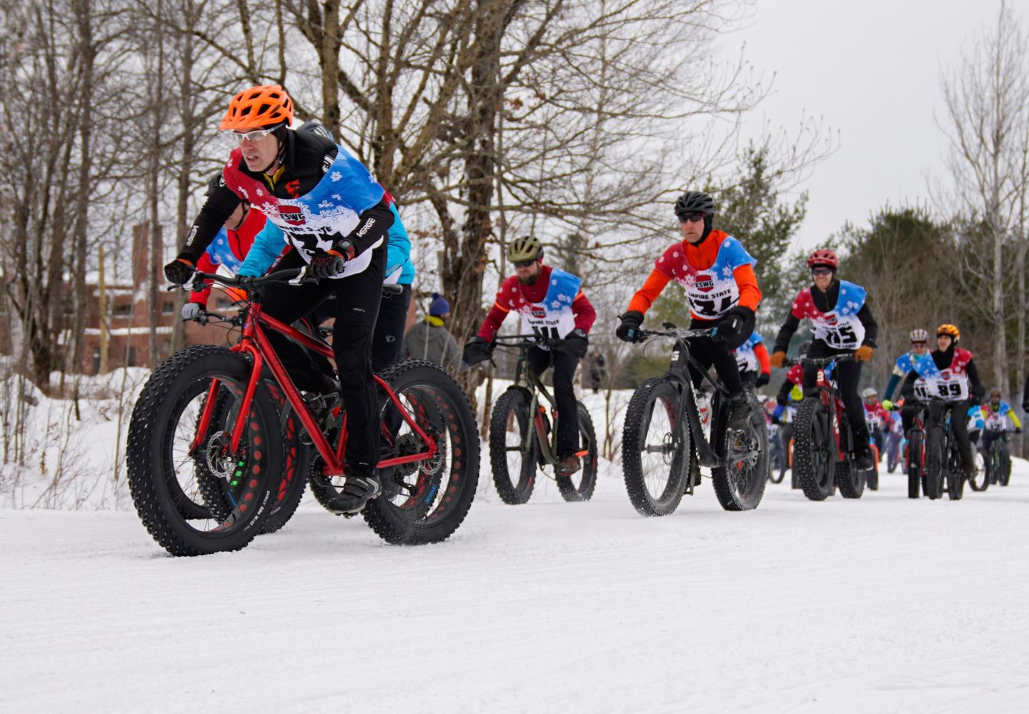 A group of racers leaves the starting line during the 2023 Empire State Winter Games Winter Bike races held at Dewey Mountain Recreation Center in Saranac Lake.