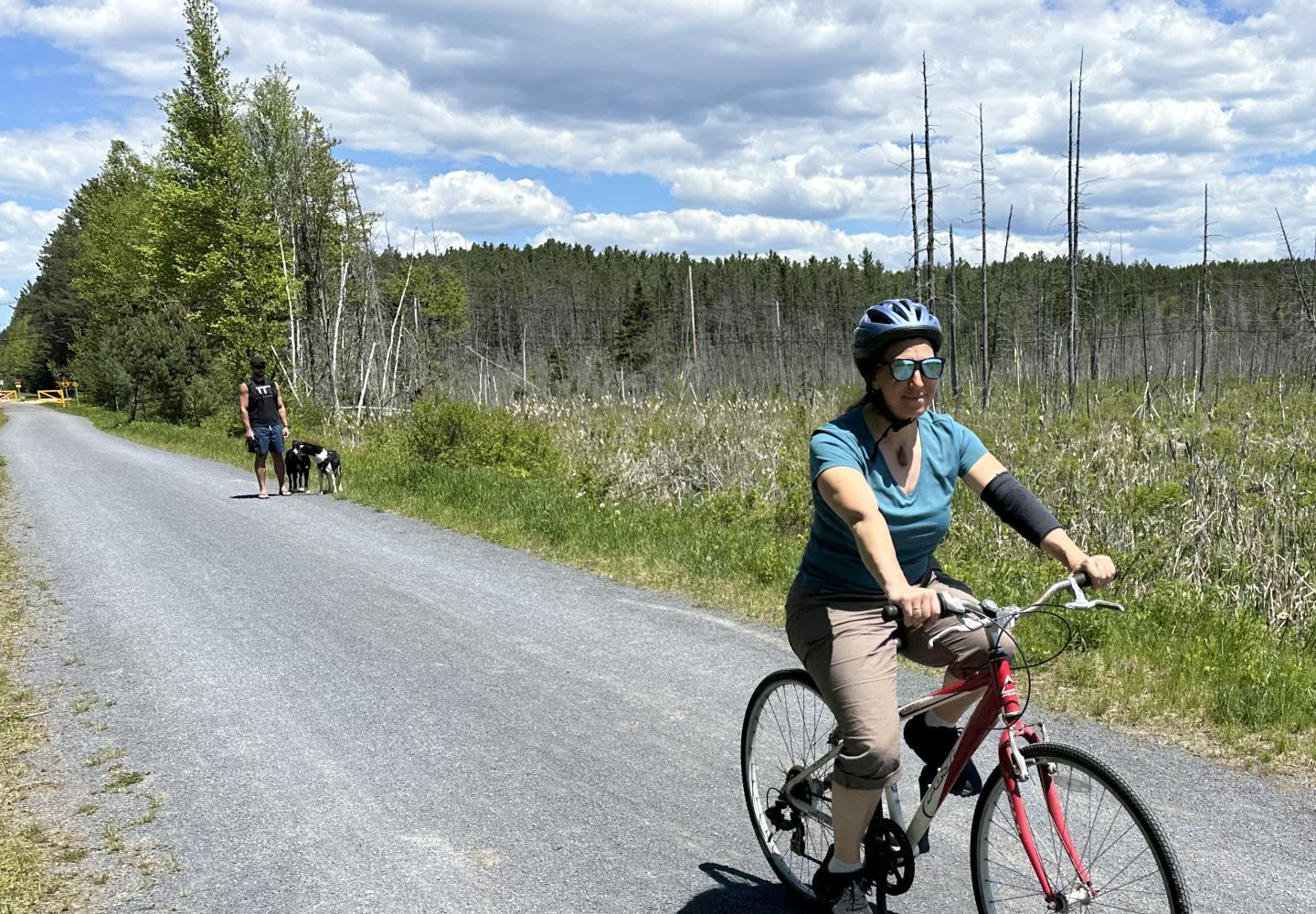 Executive Director of the Adirondack Rail Trail, Julia Goren rides a bicycle on the new vehicle-free corridor.