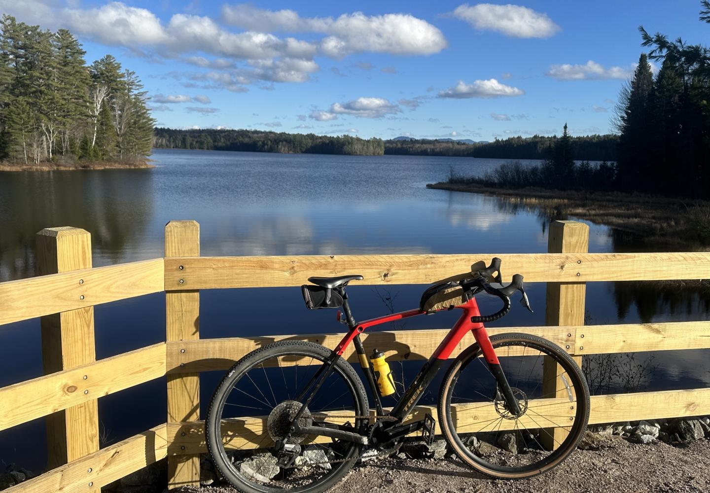 A bicycle leans agains a railing at Rollins Pond.