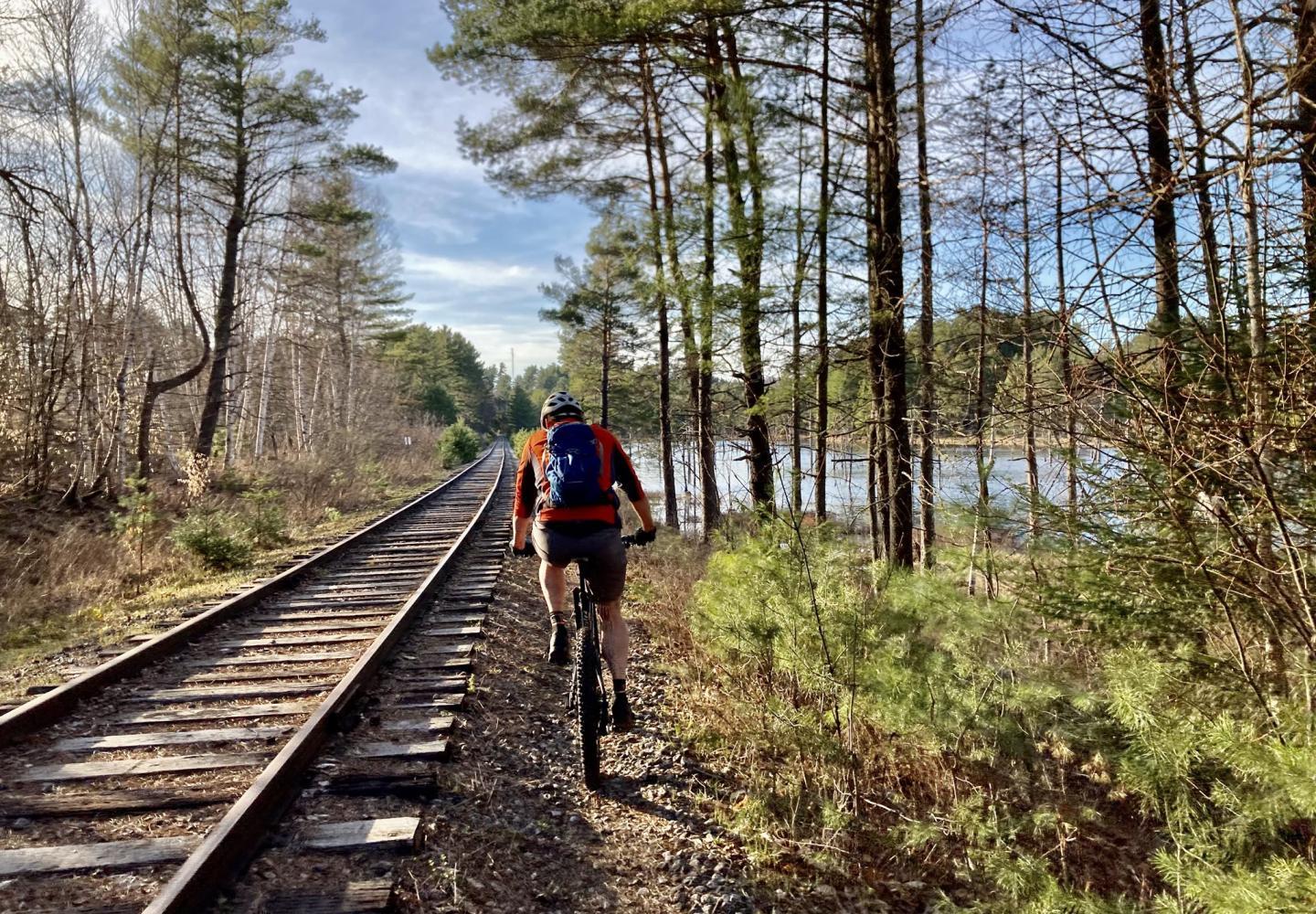 A cyclists rides alongside the Adirondack Rail Trail near Saranac Lake before the rails were removed for the new 34-mile corridor.