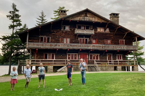 Guests play bocce on the lawn in front of the Great Camp Sagamore Main Lodge.