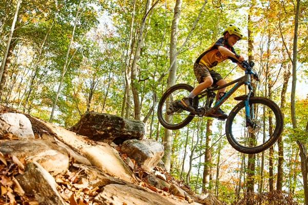 A rider clears a jump at the Wheelerville trail network in Caroga, part of the Adirondack Foothills Trails Alliance network.