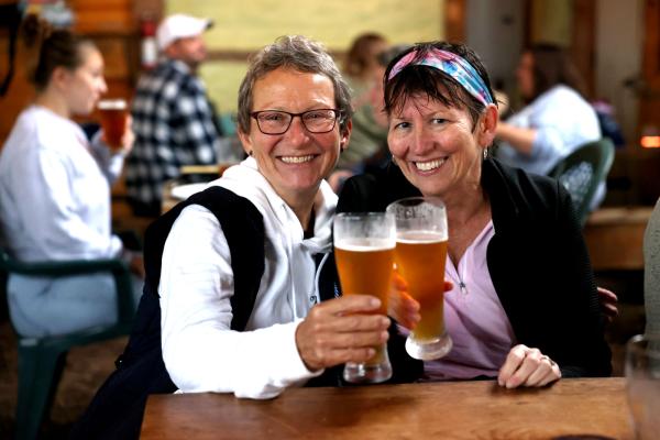 Cyclists enjoy the dry pavilion and some delicious beverages following Bike the Barns, a fundraiser for the Adirondack North Country Association.